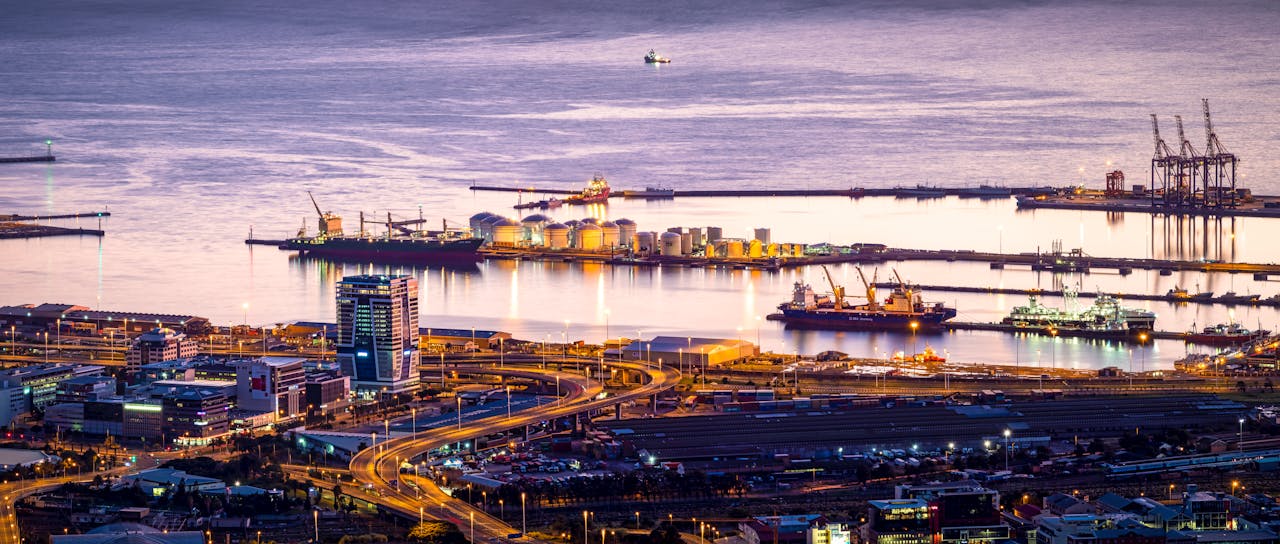 Stunning aerial view of Cape Towns bustling harbor at twilight with ships and waterfront buildings.